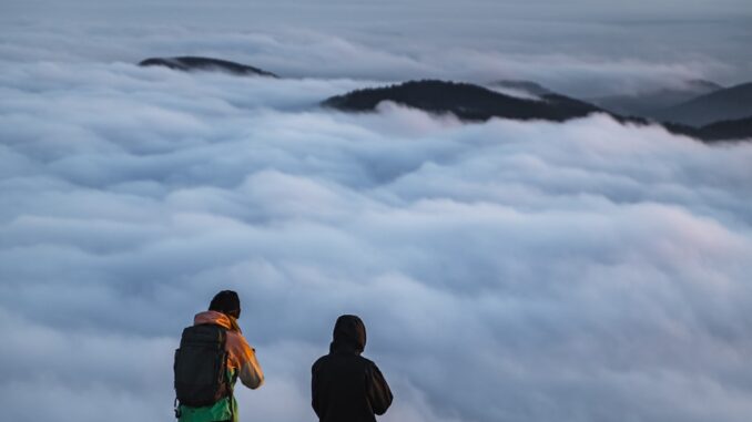 Photo un couple de personnes debout au sommet d'une colline avec un chien à Randan dans le Puy de dôme randan dans le puy de dôme une rencontre avec la nature.