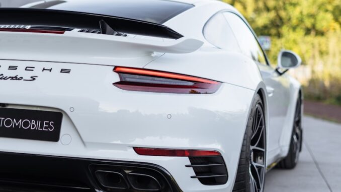 une voiture de sport Porsche blanche electrique garée devant un immeuble
